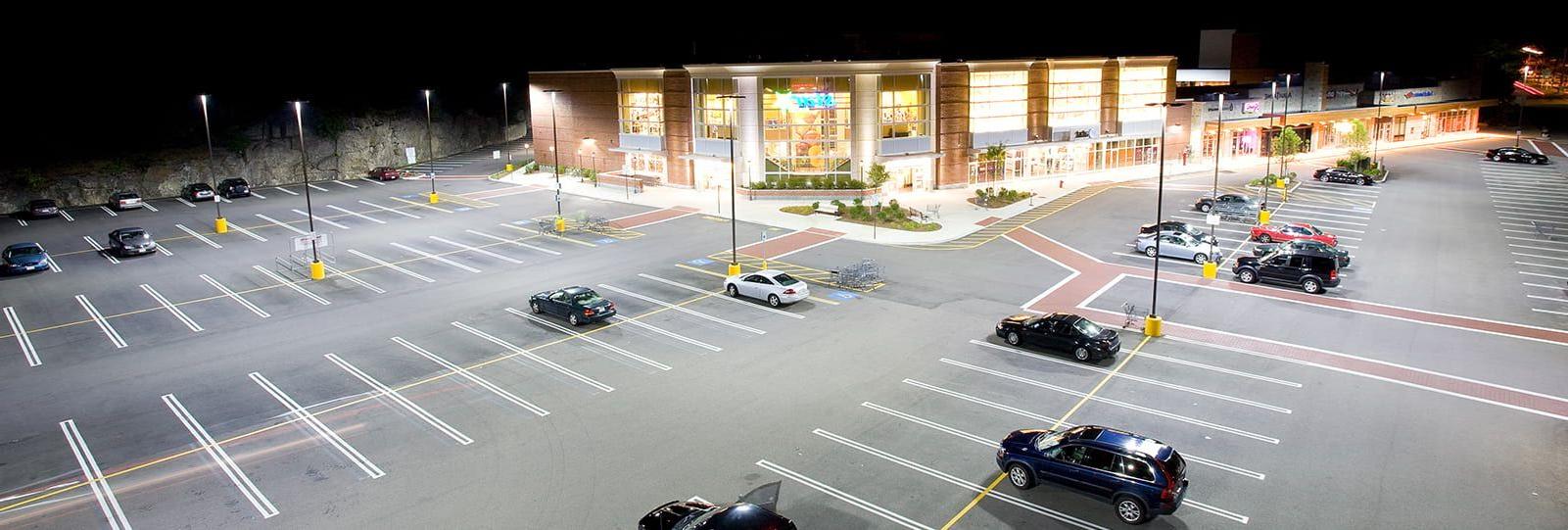 零售 store parking lot that is well lit with storefront lighting fixtures